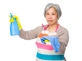Elderly housewife hold with bottle spray and rag
