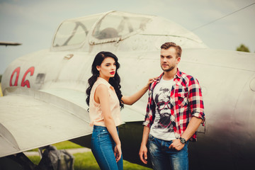 stylish couple standing near the aircraft