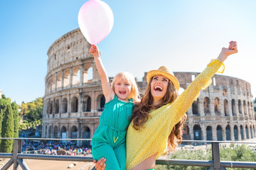 Naklejka premium Cheering mother and daughter with pink balloon at Colosseum