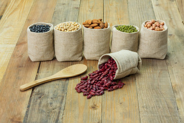 Different kinds of beans in sacks bag, focus on  scattered kidney beans