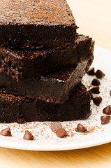 Stack of homemade brownies on white plate