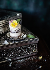 Little cake decorated with fresh viola flower. 