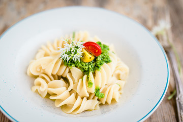 Noodles with vegan pesto and colorful tomatoes. Selective focus.