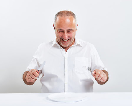 Smiley Senior Man Holding Fork With Knife