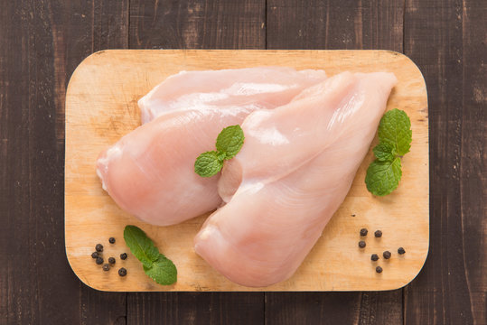 Raw chicken breast fillets on wooden background