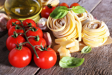 Pasta with cherry tomatoes and other ingredients on wooden table background