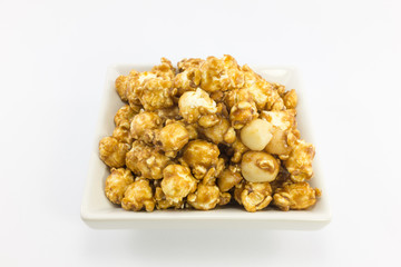 Popcorn with macadamia caramel flavour on white background.