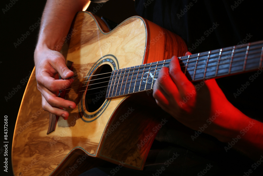 Wall mural young man playing on acoustic guitar close up