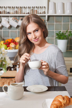 Beautiful woman drinking coffee at home
