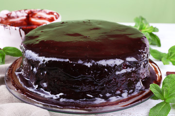 Delicious chocolate cake with icing in plate on table, closeup