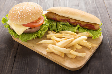 Hot dogs,hamburgers and french fries on the wooden background.