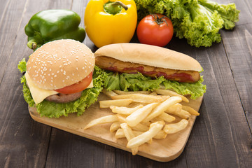 hamburgers,french fries and vegetable on the wooden background.