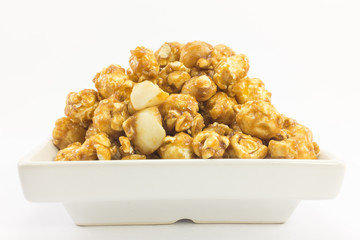 Popcorn with macadamia caramel flavour on white background.