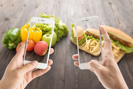Friends using smartphones to take photos with contrasting food