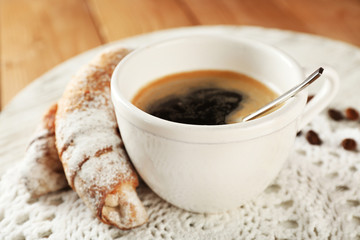 Cup of coffee with cookie on table, closeup