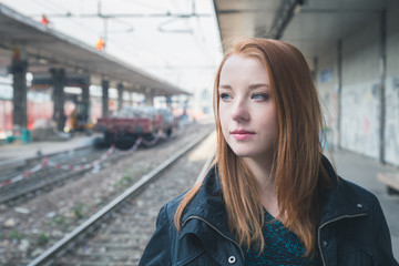 Fototapeta na wymiar Beautiful girl posing in a railroad station