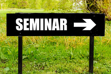 SEMINAR written on directional black metal sign