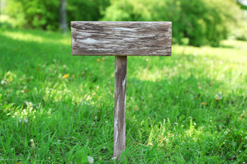 Wooden signboard over grass, outdoors