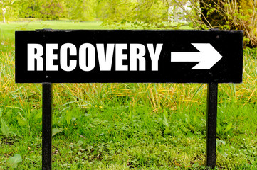 RECOVERY written on directional black metal sign