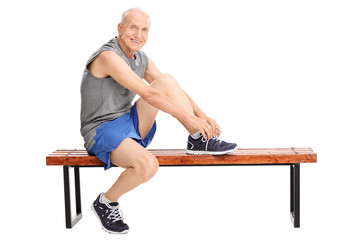 Senior in sportswear tying his shoelaces