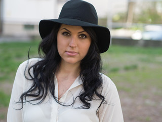 young woman in a white shirt and black hat