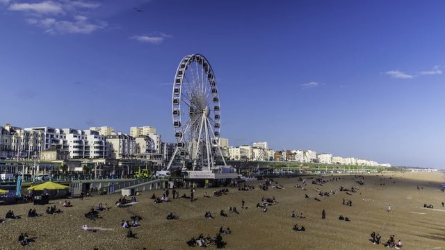 Timelipse of seaside Brighton with the Brighton wheel in a sunny spring afternoon