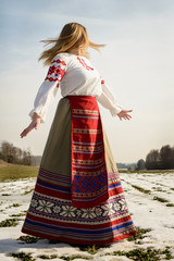 young woman in Slavic Belarusian national original suit outdoors