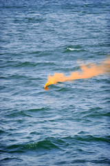 Orange smoke flare in the water