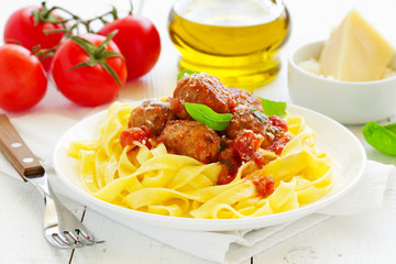 Egg tagliatelle with meatballs in tomato sauce.