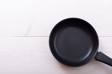 Empty pan on wooden deck table with tablecloth 