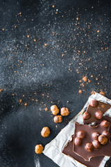 Fototapeta na wymiar Chocolate and nuts on black table