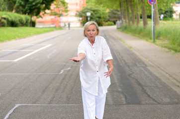 Ältere Frau alleine barfuß auf der Straße