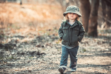 Funny little child walking in the woods