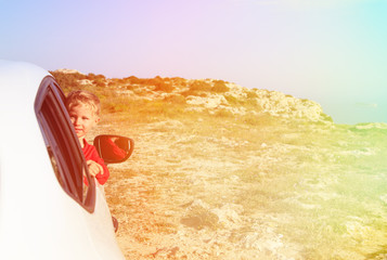 little boy travel by car in summer mountains