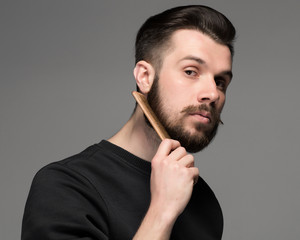 young man comb his beard and moustache 