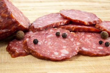 salami sausages on wooden board isolated