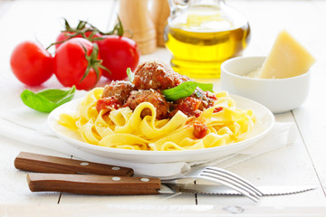 Egg tagliatelle with meatballs in tomato sauce.