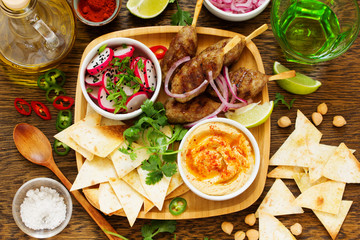 Kyufta (barbecue) of lamb with snacks (radish salad, chips and hummus.)