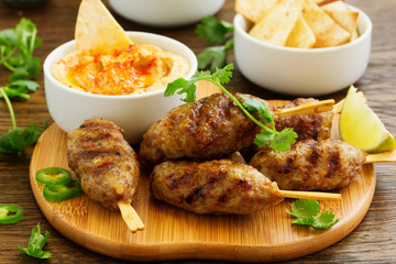 Kyufta (barbecue) of lamb with snacks (radish salad, chips and hummus.)