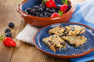 Healthy  granola bars  with fresh berries on  plate.