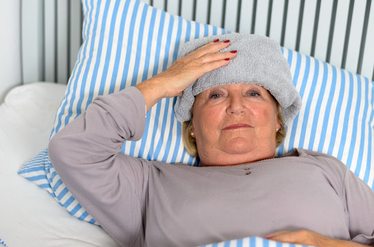 &Auml;ltere Frau liegt krank im Bett