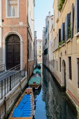 Fototapeta na wymiar Narrow channel with docked boats in san Marco, Venice, Italy