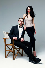 Fototapeta premium Handsome man in suit and pretty brunette female model on grey background