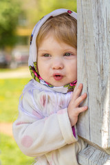 Little girl peeks out from behind the column