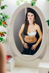Obraz na płótnie Canvas Fit woman looking in mirror