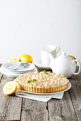 Lemon meringue pie on plate on grey wooden background