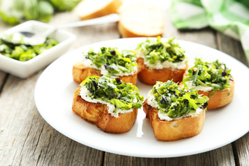 Tasty fresh bruschetta on plate on grey wooden background