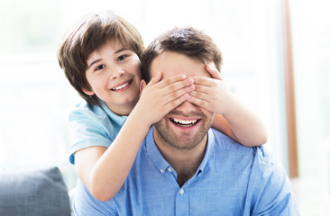 Fototapeta premium Boy covering father's eyes