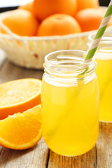 Orange juice in bottle on grey wooden background