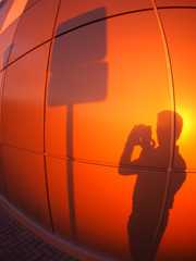 The silhouette of a man on a red-orange wall